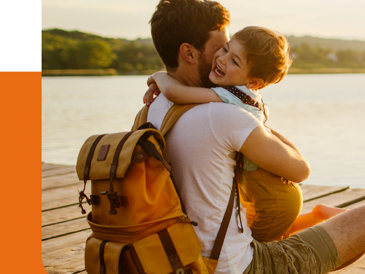 Man holding smiling child on a pier