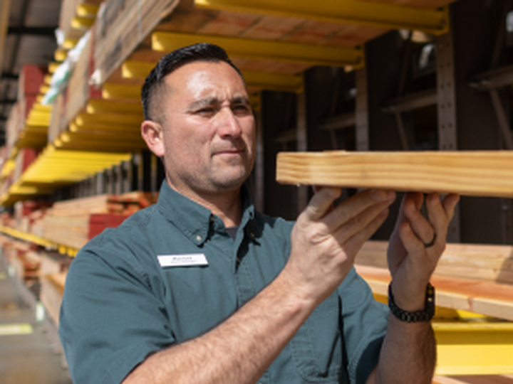 Exchange Bank Business Customer Friedmans Home Improvement employee carrying lumber.