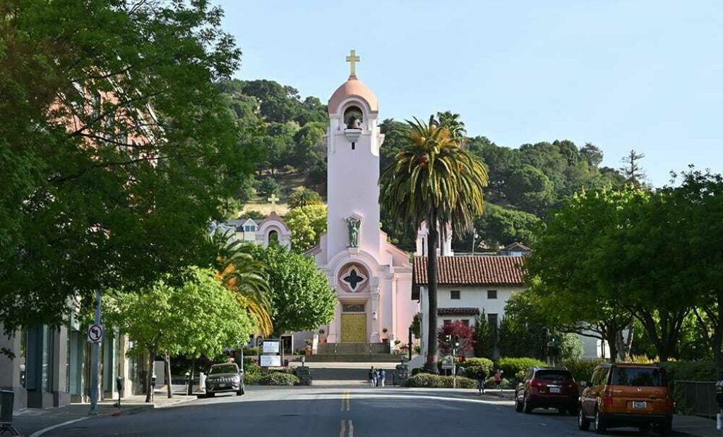 Tree-lined street with historic, tiled roof church near Exchange Bank San Rafael location.